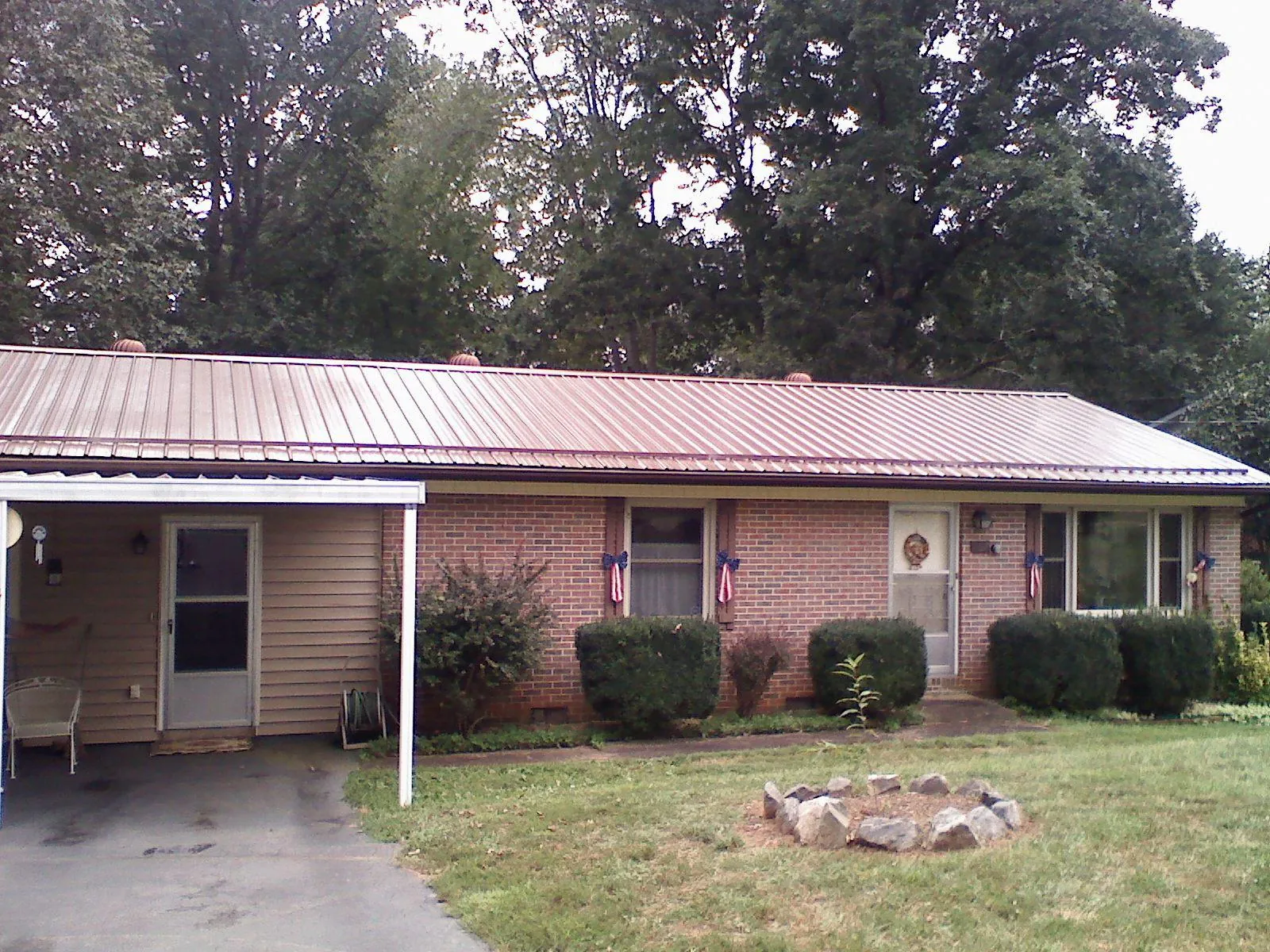 Bronze metal roof and carport on a brick ranch home — Roof Repair work by our crew in Canby